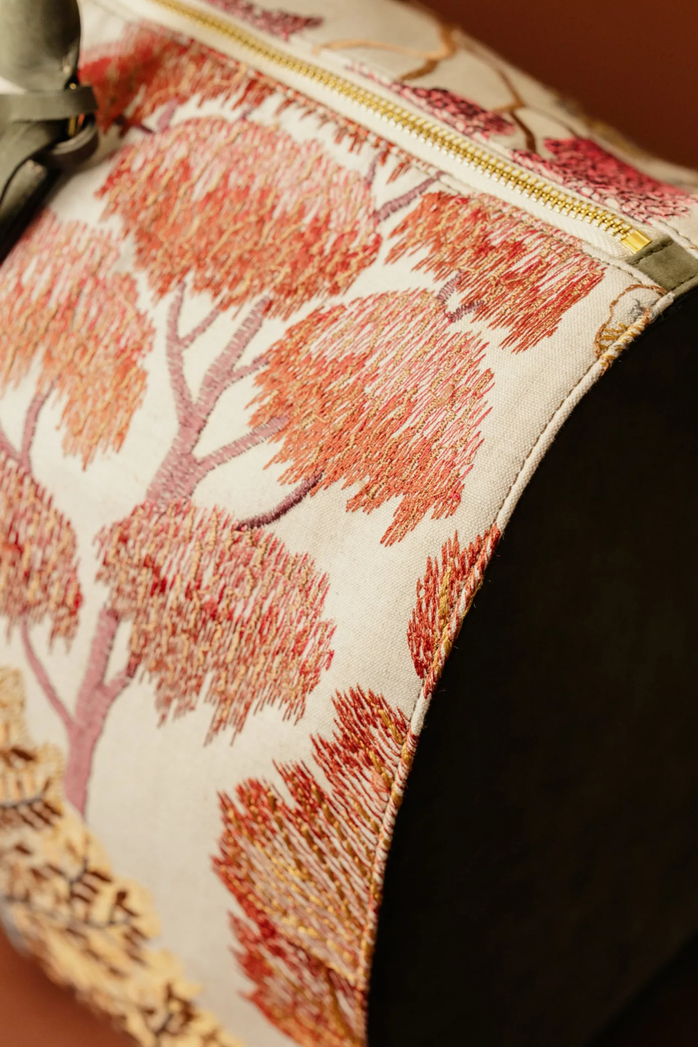 Une broderie d’arbres corail sur une toile écrue, bordée d’un passepoil.