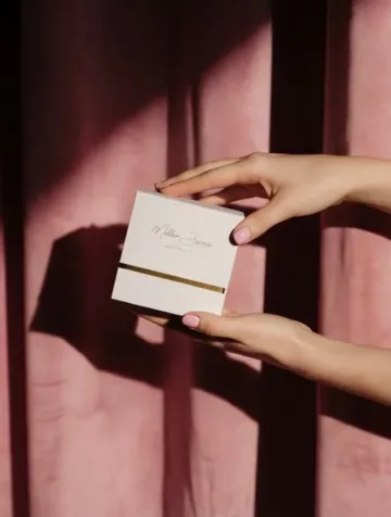 A presentation case offered against a pink velvet curtain.
