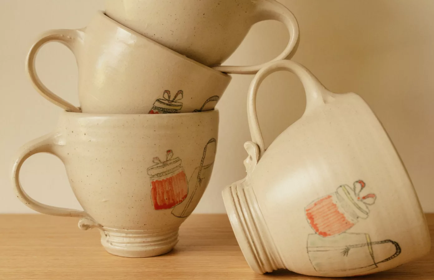 Stacked pale ceramic cups with a line-drawn design, bespoke lifestyle objects by Maison Maëstra