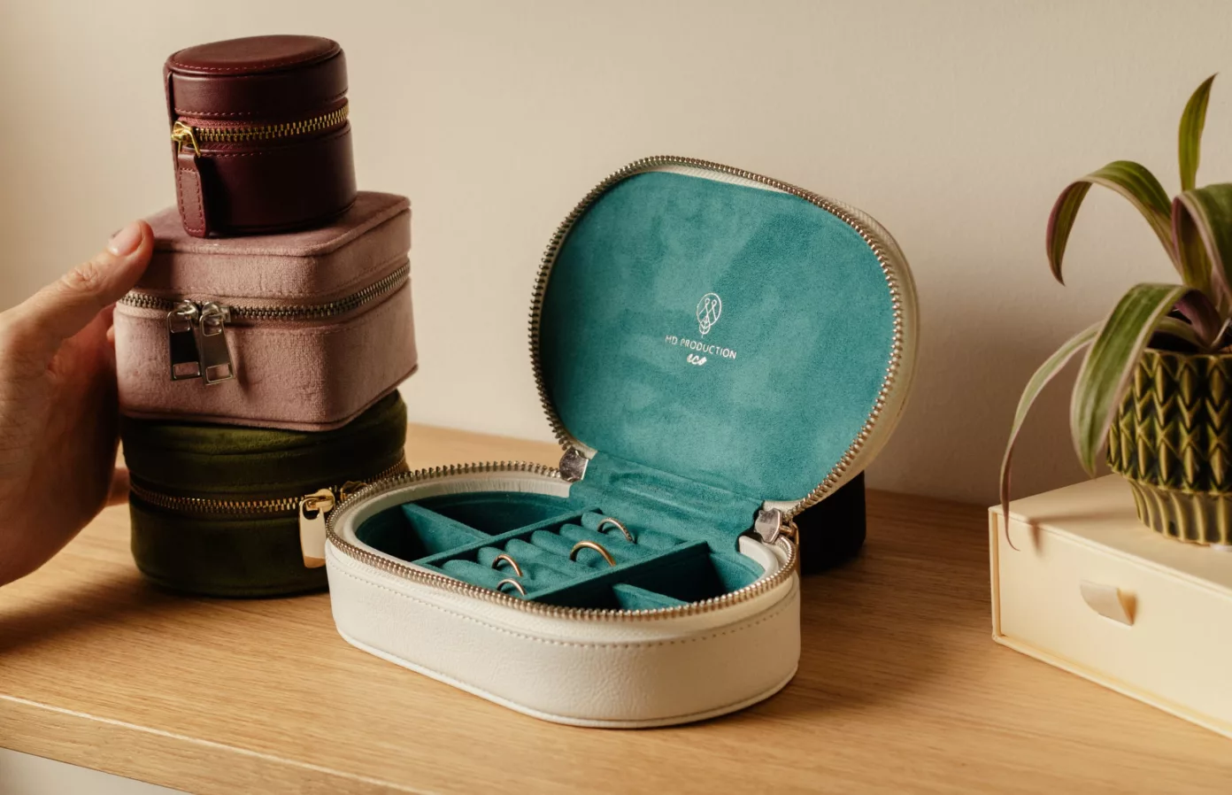 Coffret à bijoux ovale ouvert sur des bagues, écrins ronds empilés sur une étagère, écrins de joaillerie, Maison Maëstra
