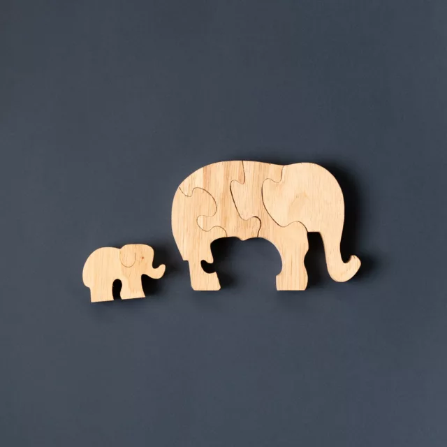 Puzzle en bois clair en forme d’éléphant et de son petit, sur fond ardoise, Maison Maëstra