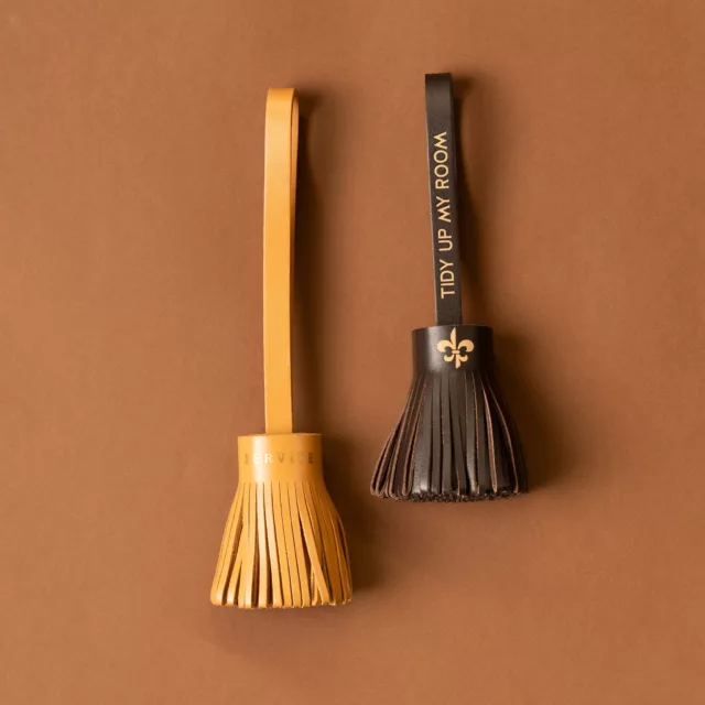 Ochre and chocolate leather tassel door hangers marked Service and Tidy up my room, hotel room accessories