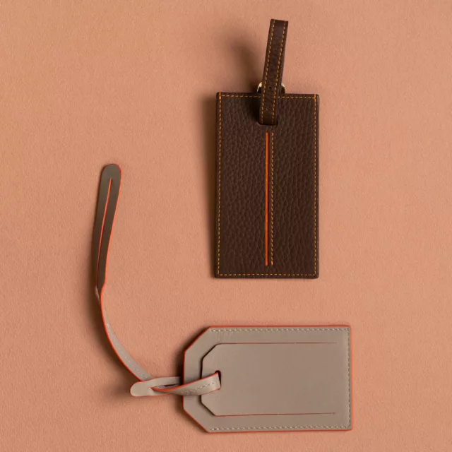 Deux étiquettes bagage en cuir, grainé chocolat et lisse taupe, coutures et tranches orange, voyage sur-mesure