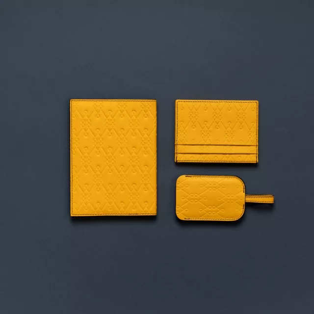 Porte-passeport, porte-cartes et étiquette en cuir jaune moutarde embossé d’un motif géométrique, voyage sur-mesure